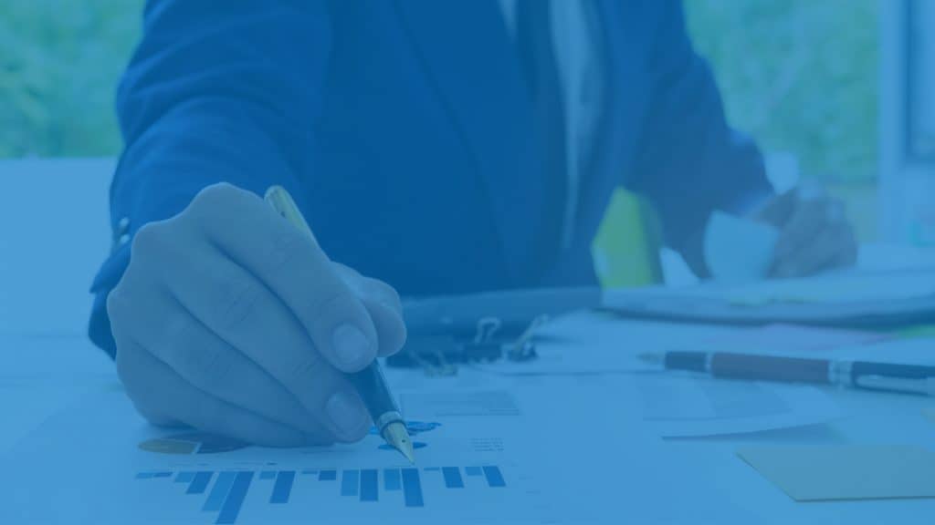 Ein Geschäftsmann macht mit einem Füller auf einer Grafik ein paar Notizen