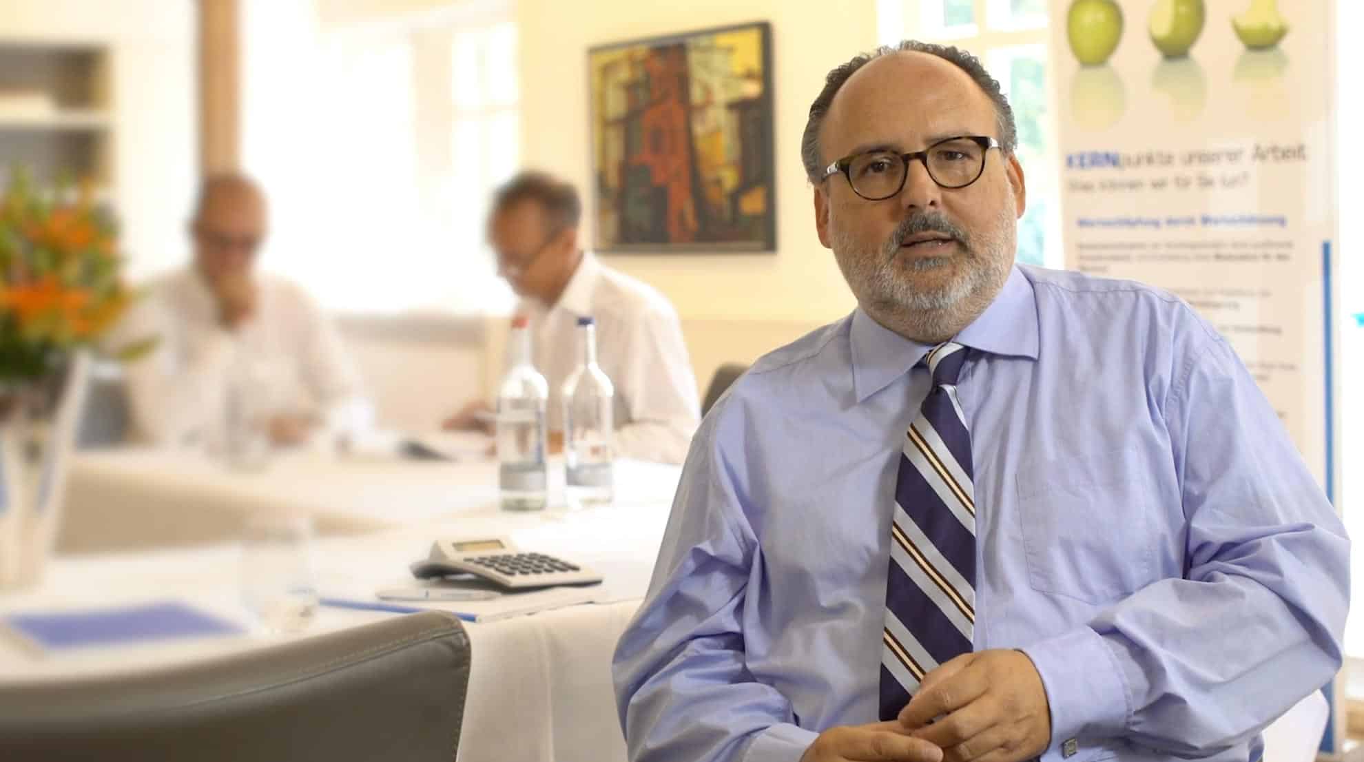 Nils Koerber Gründer von KERN ( eine M&A Beratung für Unternehmensverkauf in Bremen) sitzt an einem Tisch