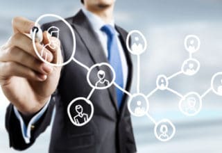 Geschäftsmann vor Plexiglasscheibe mit einem weißen Stift eine Mind Map malend