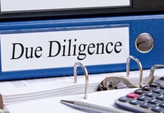 Bild eines blauen Aktenorders mit der Aufschrift "Due Diligence"