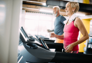 Eine ältere Dame und ein älterer Herr halten sich beim Cardio fit