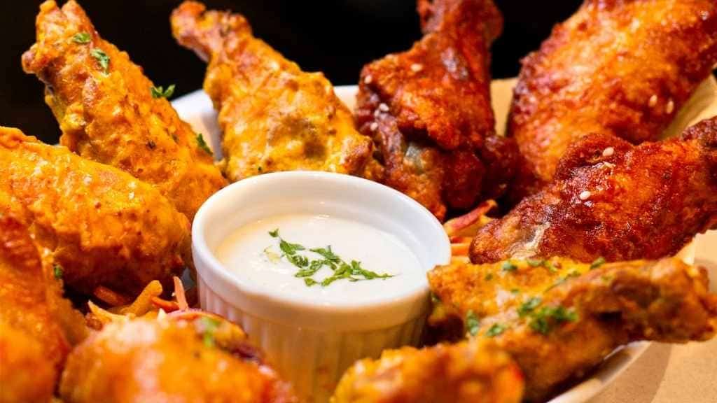 Chickenwings auf einem Teller mit Sourcream