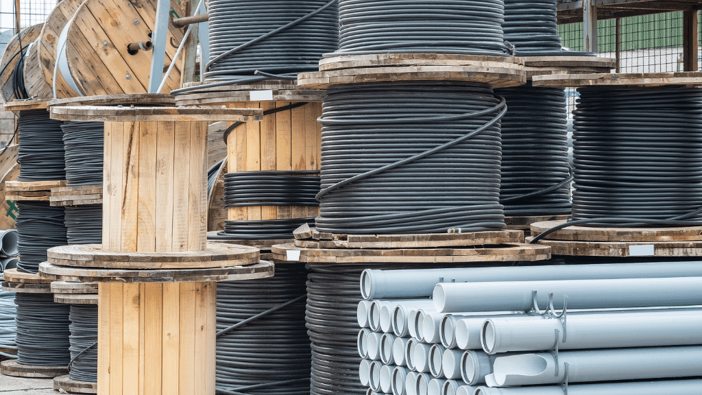 Rohre und riesige Rollen mit Kabeln