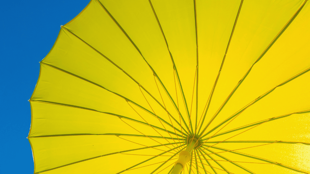 Gelber Sonnenschirm mit blauem Himmel
